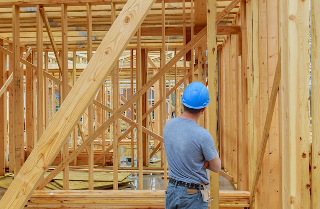 Um trabalhador de construção de um dia carregando vigas de madeira um trabalhador da construção autêntico em uma construção real