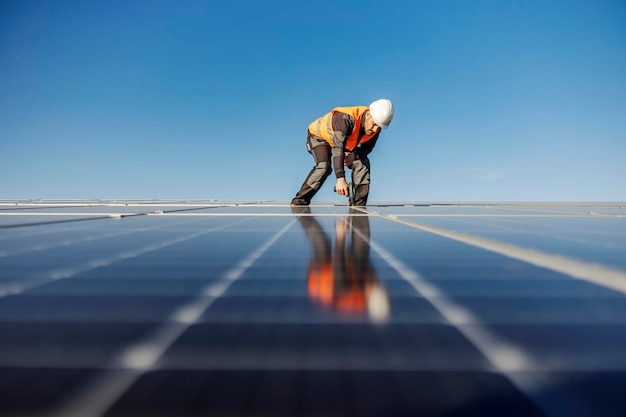 Um trabalhador instalando painéis solares no telhado