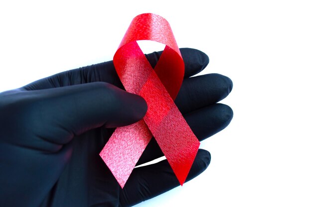 Um trabalhador médico está segurando uma placa da luta contra a aids