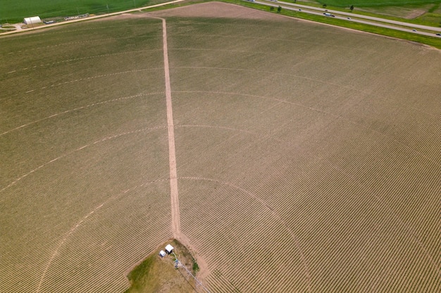 um tractor está num campo com um campo arado em primeiro plano.