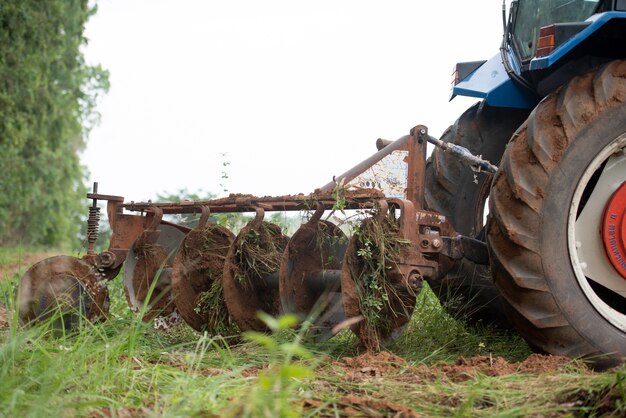 Um trator azul trabalhando em terras agrícolas