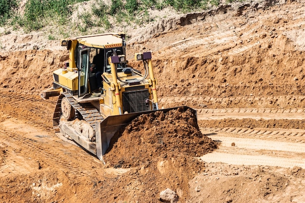 Um trator poderoso em um poço de areia está planejando um local Extração de areia em um poço aberto materiais de construção naturais