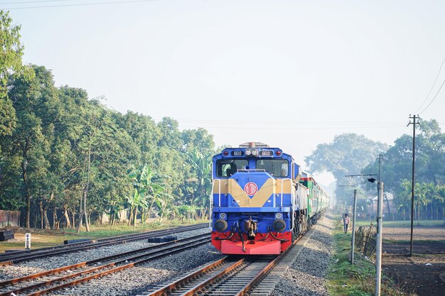 um trem está descendo os trilhos com um logotipo vermelho e amarelo na frente