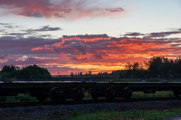 Um trem está nos trilhos ao pôr do sol