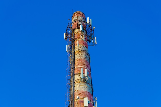 Um tubo de tijolo antigo com antenas de comunicação celular.