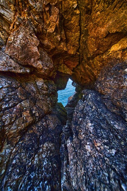Um túnel de rochas afiadas que leva à água do oceano