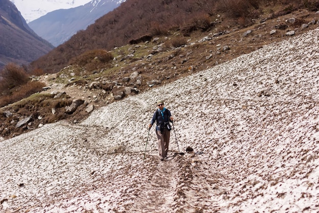 Um turista caminha por um caminho na encosta das montanhas do Himalaia na região de Manaslu