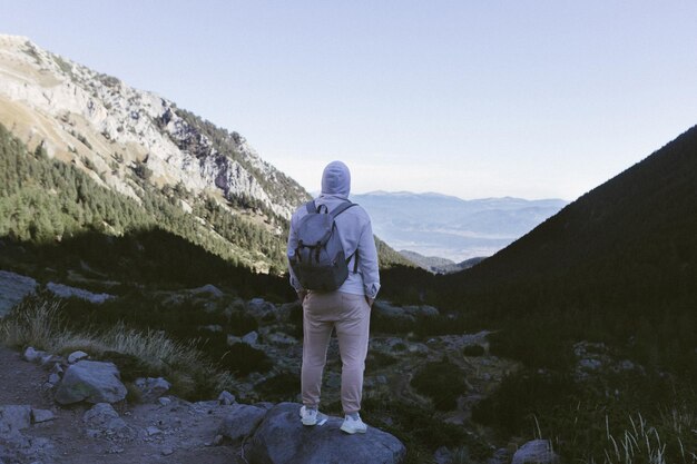 Um turista está no pico de uma montanha