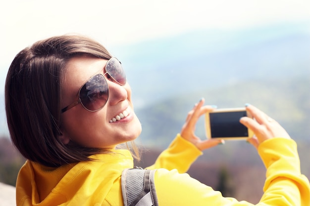 um turista feliz tirando fotos nas montanhas