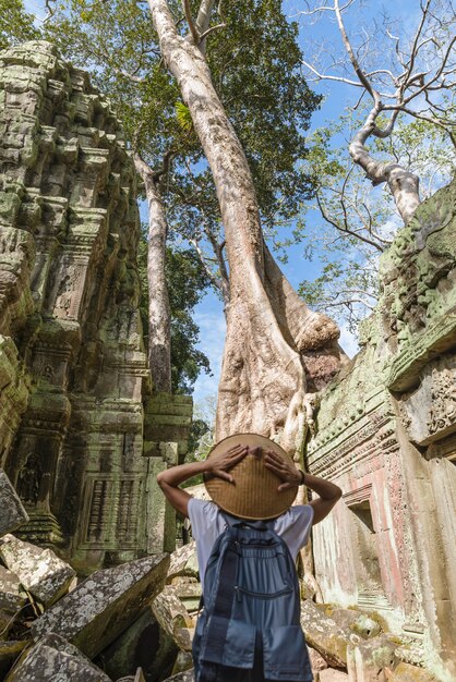 Um turista que visita ruínas de Angkor em meio a selva