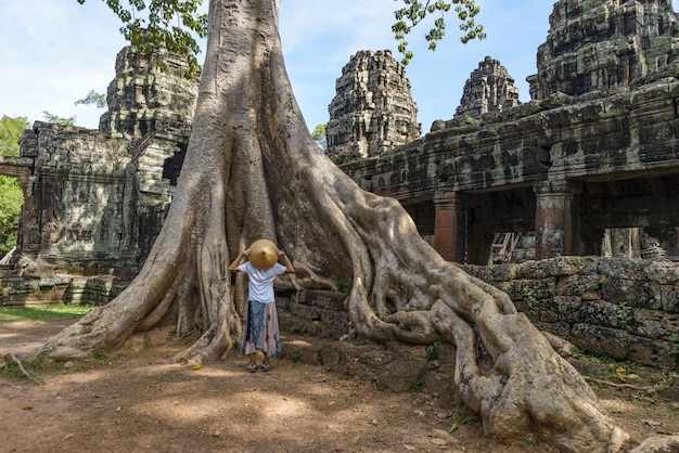 Um turista que visita ruínas de Angkor em meio a selva