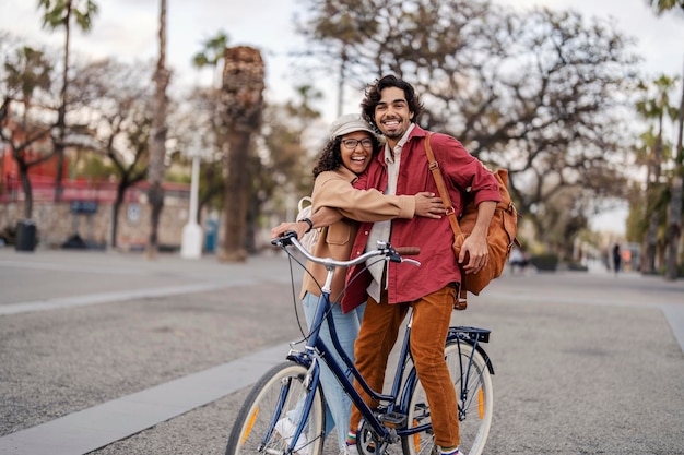 Um turista romântico feliz com bicicleta está se abraçando em uma rua da cidade na Espanha e sorrindo para a câmera