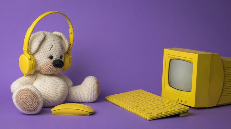 Um urso de malha na frente de um computador amarelo sobre um fundo roxo.