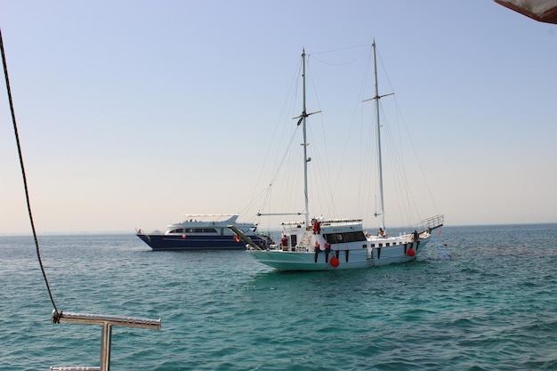 Um veleiro a navegar no mar contra um céu claro.