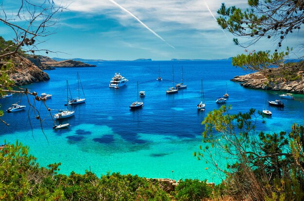 Um veleiro e um iate na baía da lagoa turquesa de Cala Salada