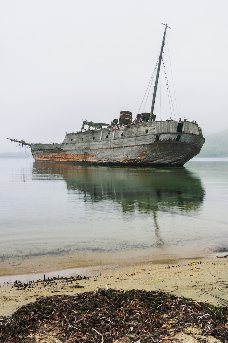 Foto um velho barco baleeiro soviético de madeira encalhou na costa da baía