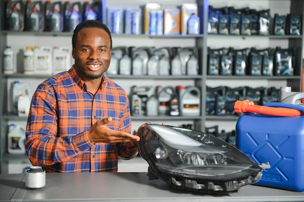 Foto um vendedor africano sorridente numa loja de peças de automóveis.