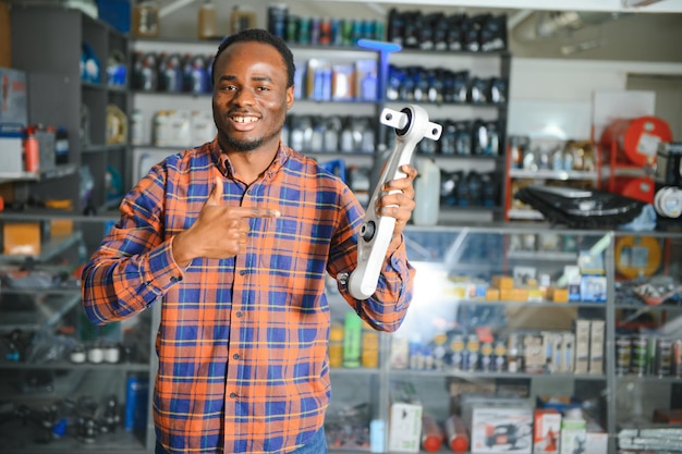 Foto um vendedor africano sorridente numa loja de peças de automóveis.