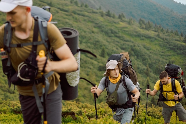 Um viajante estiloso em roupas amarelas de turista percorre uma rota turística de montanha nas montanhas dos Cárpatos da Ucrânia