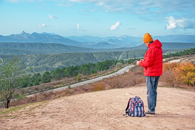 Um viajante nas montanhas olha para um gadget