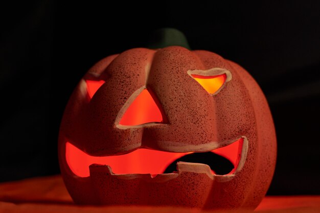 Uma abóbora brilhante esculpida em um fundo escuro - conceito de halloween