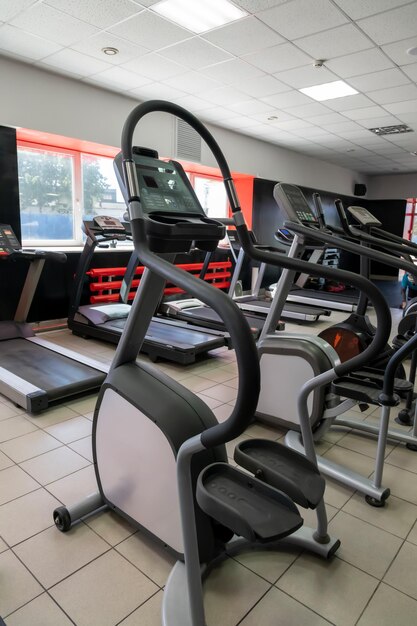 Uma academia com esteiras e uma janela com os dizeres gym