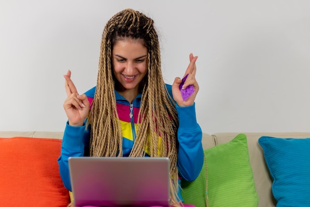 Foto uma adolescente bonita a fazer compras online com o cartão de crédito e um computador portátil em casa.