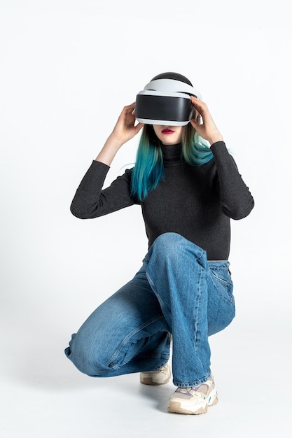 Uma adolescente coloca um capacete vr para entrar no universo virtual isolado em um quadro vertical de fundo branco O conceito do universo virtual Estilo de vida no espaço virtual