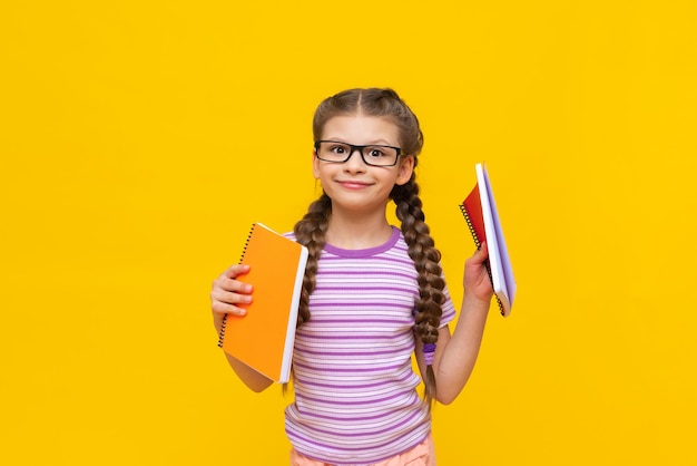 Uma adolescente com cadernos coloridos nas mãos e óculos Uma garotinha se preparando para a escola Cursos adicionais para a criança