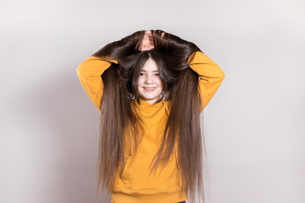 Uma adolescente de 12 anos com cabelos naturais muito longos sorri.