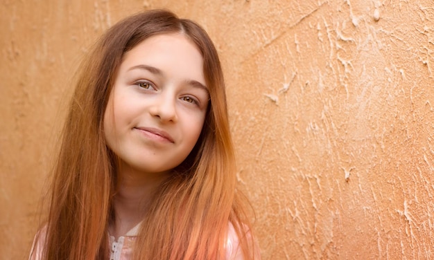 Uma adolescente em uma jaqueta rosa em um fundo bege Retrato de uma linda garota