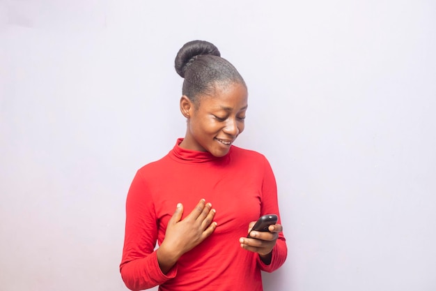 Uma adolescente negra atraente sorrindo segurando o celular