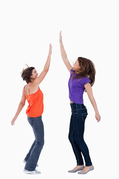 Uma adolescente que mantém a mão no ar enquanto o melhor amigo dela quer tocar