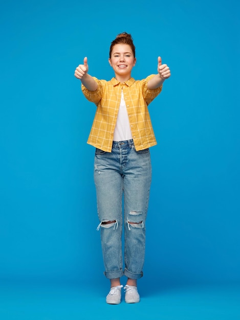 uma adolescente ruiva feliz mostrando os polegares para cima