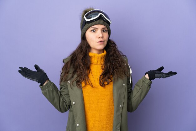 Foto uma adolescente russa com óculos de snowboard isolados em um fundo roxo