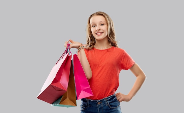 uma adolescente sorridente com sacos de compras