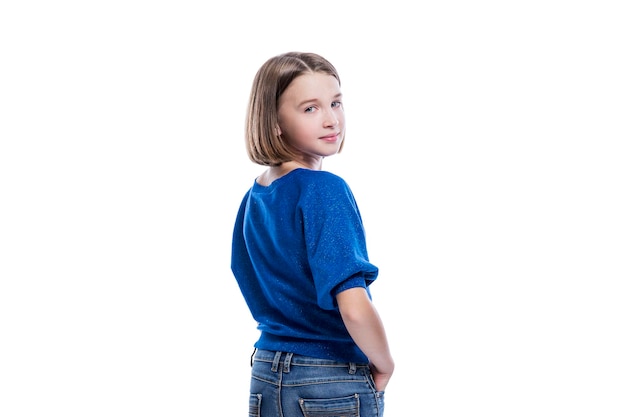 Uma adolescente sorridente em jeans e um suéter azul virou Positividade e alegria Isolado em fundo branco Vista traseira