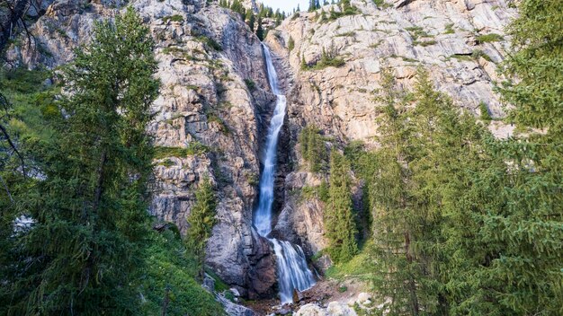 Foto uma alta cachoeira em cascata em um desfiladeiro da montanha