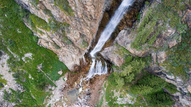 Foto uma alta cachoeira em cascata em um desfiladeiro da montanha