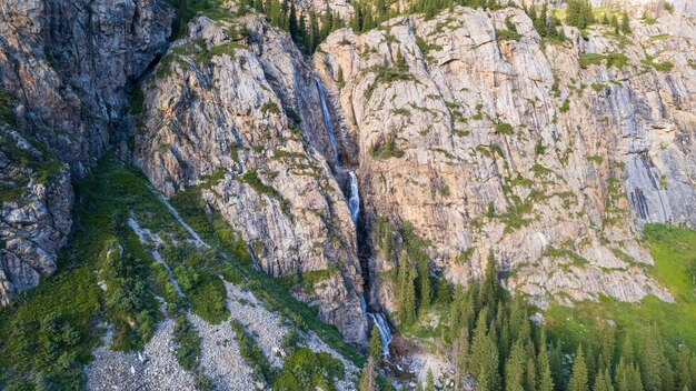 Foto uma alta cachoeira em cascata em um desfiladeiro da montanha