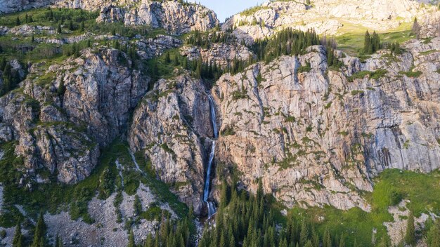 Foto uma alta cachoeira em cascata em um desfiladeiro da montanha