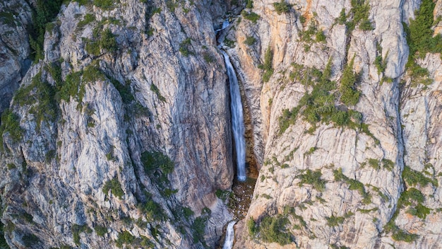 Foto uma alta cachoeira em cascata em um desfiladeiro de montanha