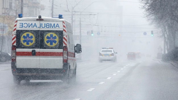 Uma ambulância levou o paciente para a clínica com os indicadores luminosos ligados. Mau tempo lá fora, chuva com neve molhada.