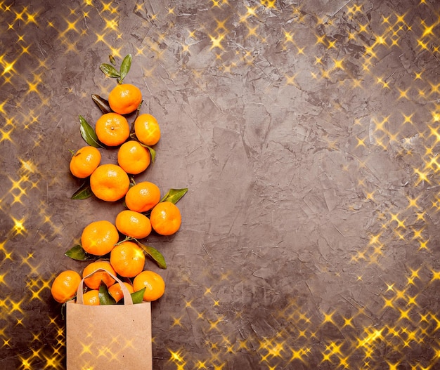 Uma árvore de natal feita de tangerinas inteiras em um fundo cinza com luzes