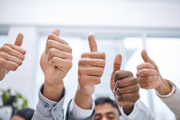 Uma atitude positiva faz toda a diferença Foto de um grupo de empresários mostrando os polegares para cima