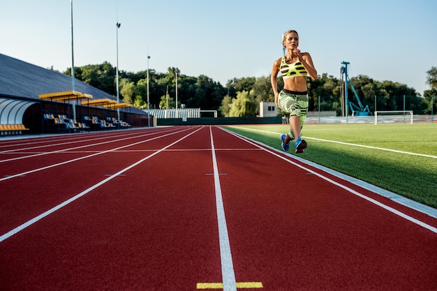 Uma atleta corre ao longo da esteira esportiva