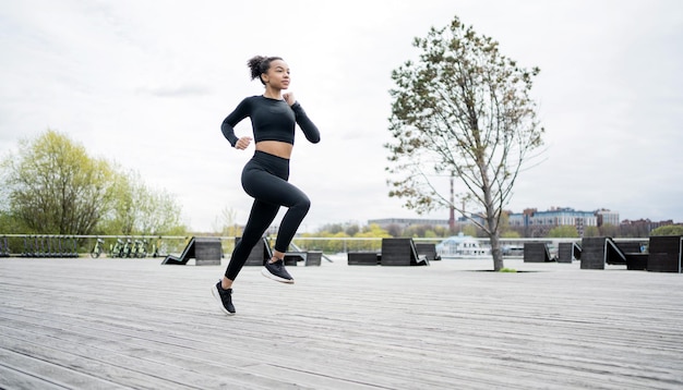 Uma atleta feminina corre faz um treino ao ar livre em relógios esportivos e fitness