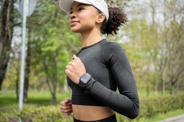 Foto uma atleta feminina corre faz um treino ao ar livre em relógios esportivos e fitness