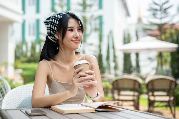 Uma atraente mulher asiática sonhando acordada com algo enquanto estava sentada em um belo jardim