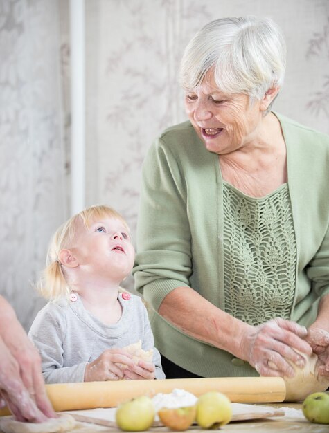 Uma avó fazendo tortas com uma garotinha
